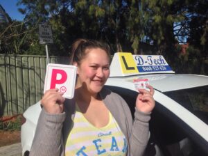 Successful driver holding P-plates following testing day verification with D-Tech Driver Training at Castle Hill.