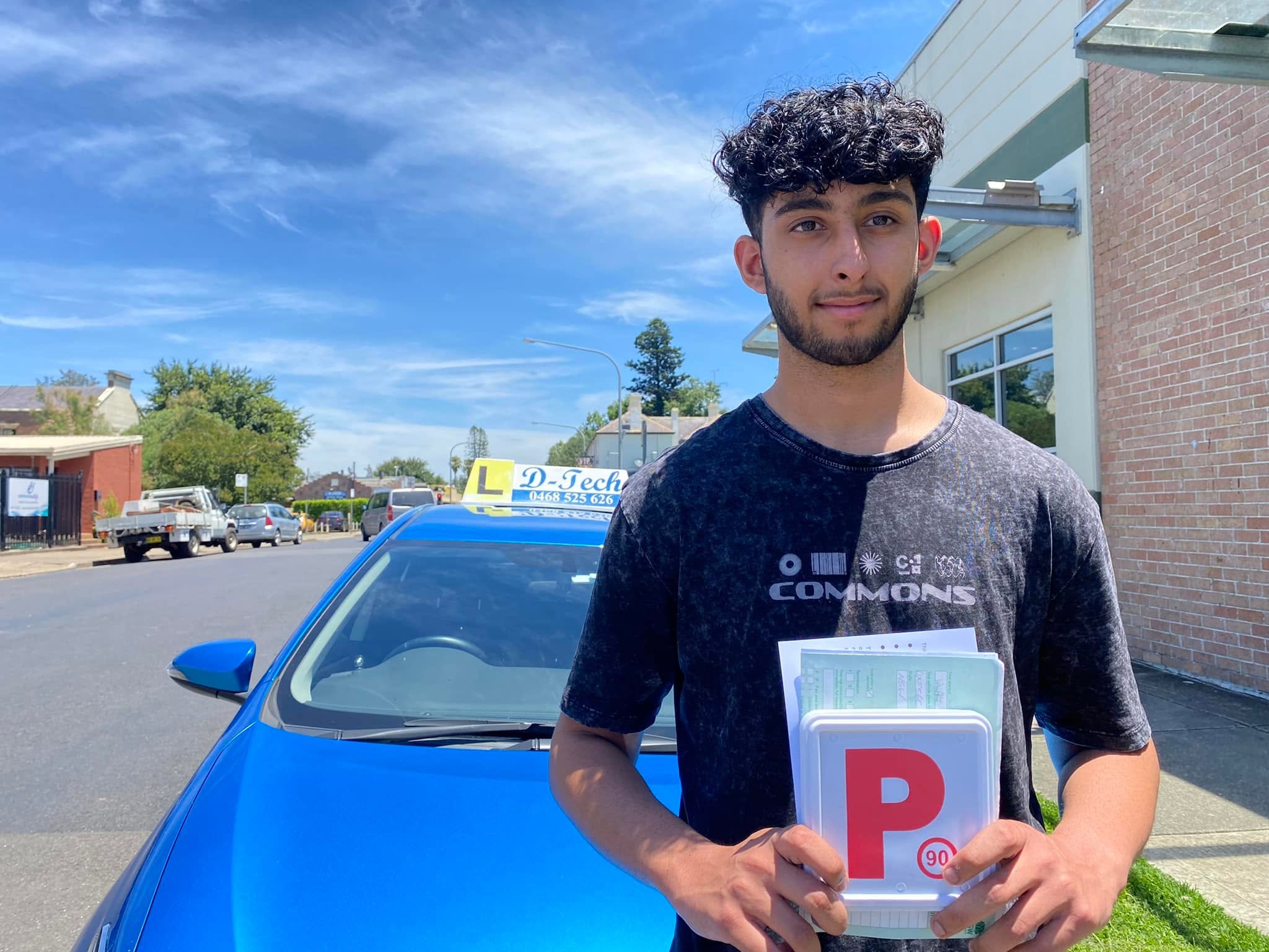 RMS-accredited driving instructor standing next to a D-Tech Driver Training dual-control car in Richmond NSW.