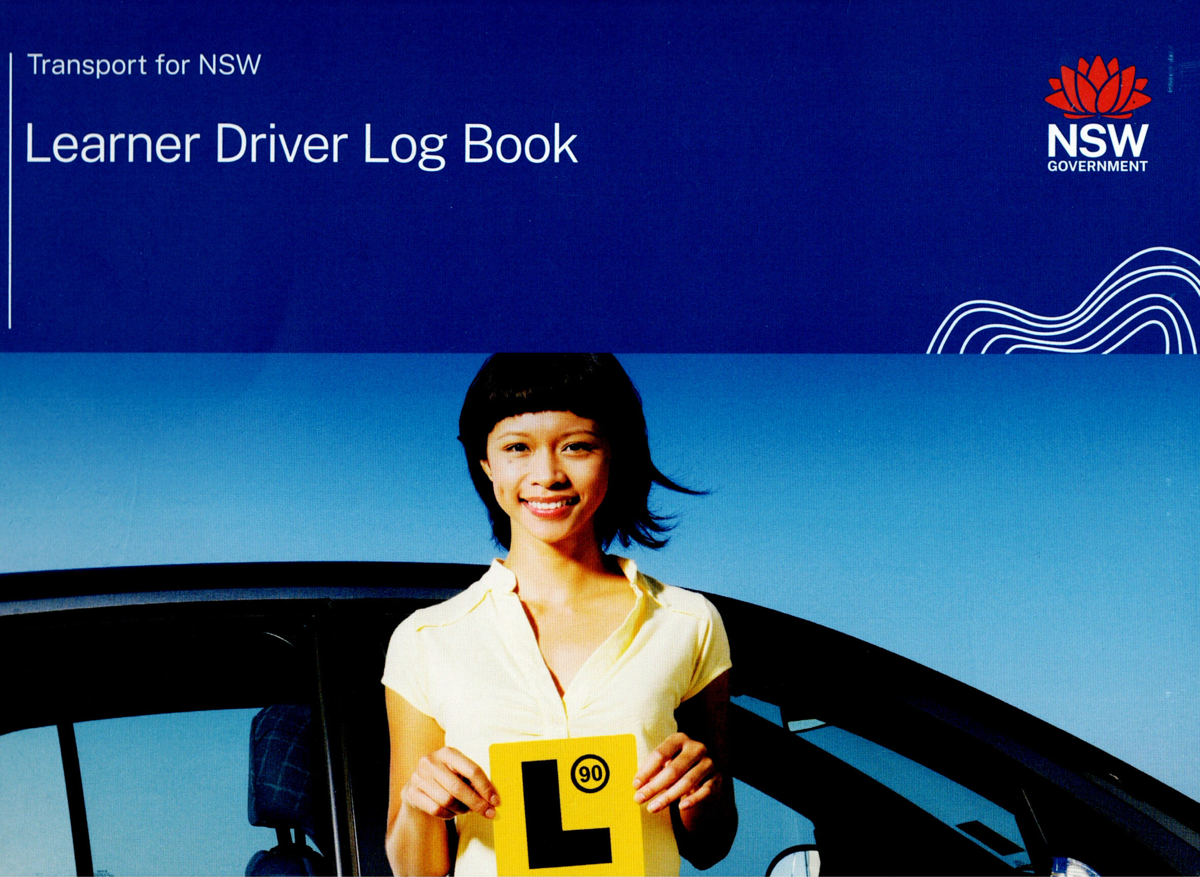 A young driver smiling while holding up a yellow L-plate in front of a car, representing the official Transport for NSW Learner Driver Log Book.